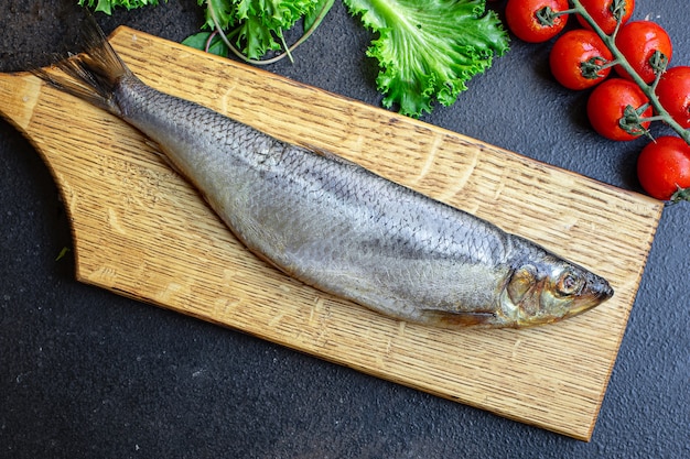 Poisson hareng cru sur une planche de bois