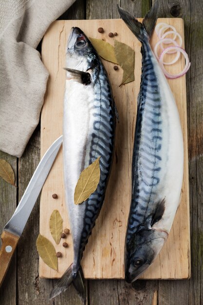 Poisson maquereau cru avec des ingrédients pour la cuisson sur un vieux fond en bois de style rustique. .