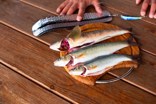 Poisson de mer frais se trouve sur une planche à découper sur une table en bois