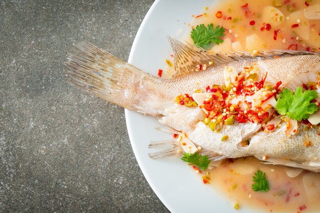 Poisson de mérou cuit à la vapeur avec citron vert et piments - style cuisine asiatique