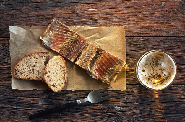 Poisson sur un papier avec du pain et un verre de bière