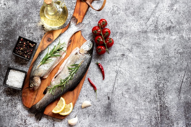 Poisson sur une planche à découper avec légumes et citrons