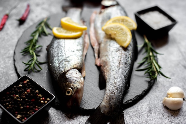 Un poisson sur une planche à découper avec des tranches de citron dessus.