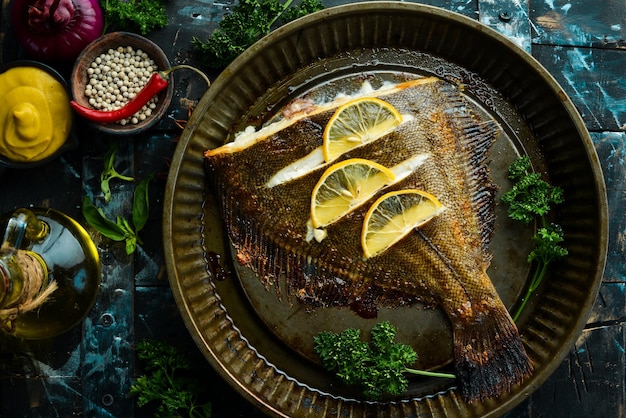 Poisson plie cuit au four avec du citron et des épices sur un plat de cuisson en métal Vue de dessus de fruits de mer Espace libre pour le texte