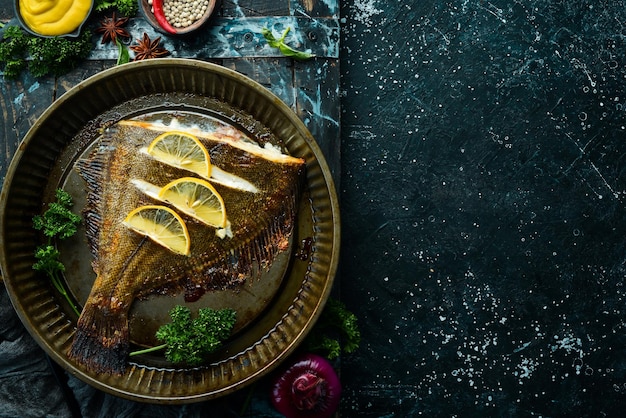 Poisson plie cuit au four avec du citron et des épices sur un plat de cuisson en métal Vue de dessus de fruits de mer Espace libre pour le texte