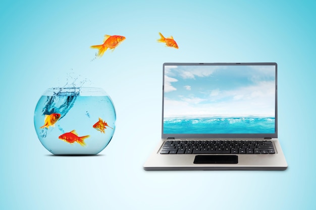 Poisson rouge sautant d'un aquarium à un écran d'ordinateur portable