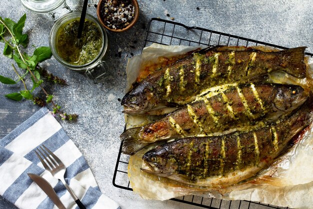 Poisson saumon cuit au four avec sauce pesto et épices culinaires sur un comptoir en pierre grise Vue de dessus