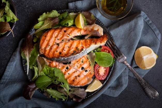 Poisson saumon cuit avec des légumes sur fond sombre