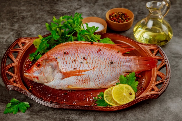 Poisson tilapia cru rouge aux herbes, épices et huile d'olive.