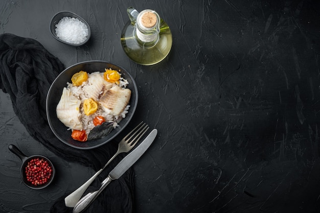 Poisson tilapia avec riz basmati et tomates cerises, dans un bol, sur table noire, vue du dessus