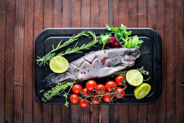 Poisson truite aux herbes aromatiques et épices sur fond de bois