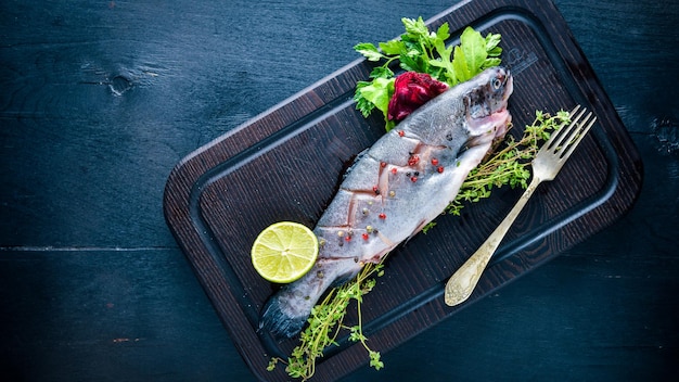 Poisson truite aux herbes aromatiques et épices sur fond de bois