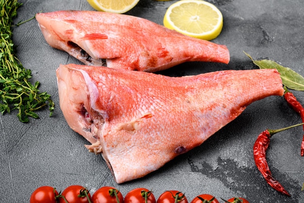 Poisson de vivaneau rouge cru entier sur fond de table en pierre grise