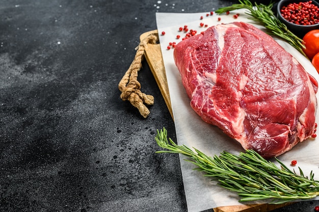 Poitrine de boeuf crue coupée sur une planche à découper en bois