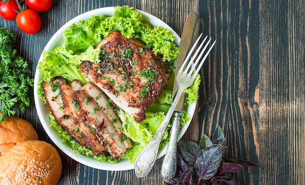 Poitrine de porc au four aux épices. Poitrine tranchée servie avec des herbes. Plat traditionnel de l'Ukraine. Fermer. Espace de copie.