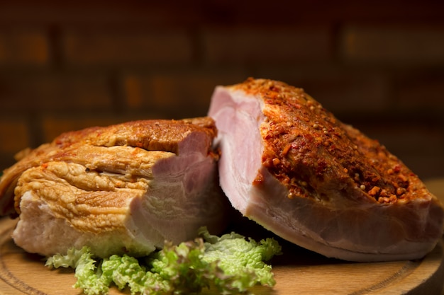 Poitrine de porc avec des feuilles de salade sur planche de bois