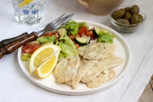 Poitrine de poulet à la crème de lait et citron, servie avec une salade de légumes frais.