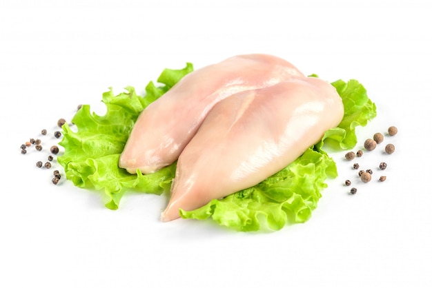 Photo poitrine de poulet cru et salade verte isolée sur fond blanc.