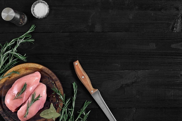 Photo poitrine de poulet crue et condiments dans une vue de dessus en bois rustique