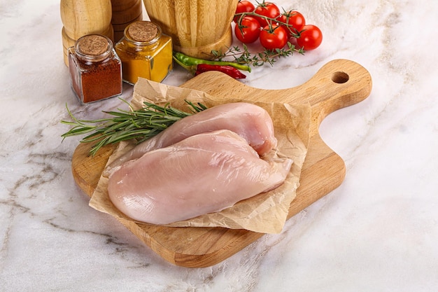 Poitrine de poulet crue servie avec du romarin