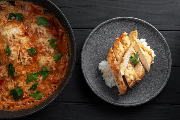 Poitrine de poulet cuite au four dans une sauce à la crème avec tomates persil vue de dessus poitrine de poulet sur une assiette tranchée