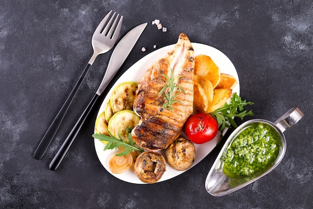 Poitrine de poulet grillade avec légumes et sauce pesto dans une poêle en fonte