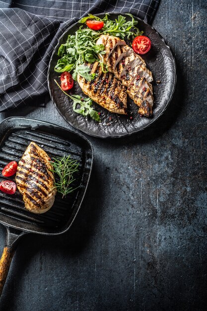 Poitrine de poulet grillée aux épices poivre sel tomates romarin et roquette - Vue de dessus.