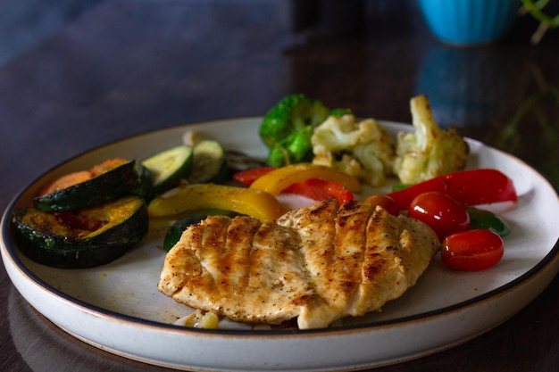 Poitrine de poulet grillée sur poivre noir avec assiette de légumes mélangés. Concept de menu d'aliments sains