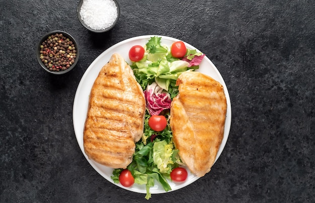 poitrine de poulet grillée et salade de tomates cerises sur fond de pierre