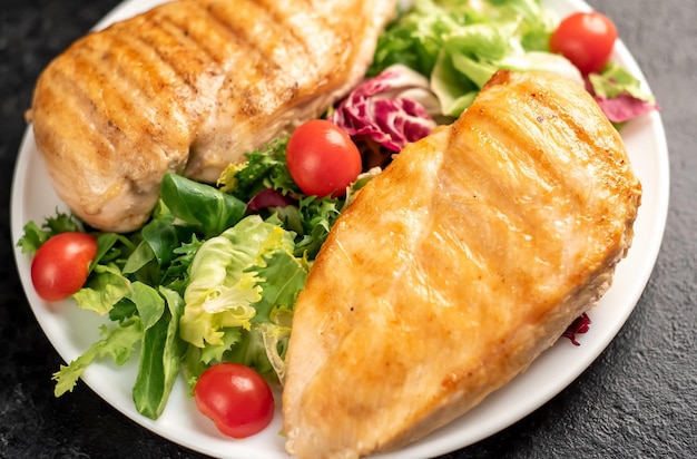 poitrine de poulet grillée et salade de tomates cerises sur fond de pierre