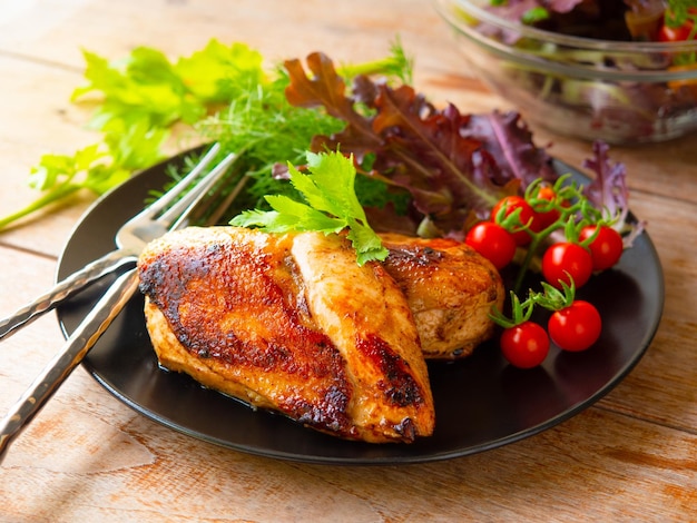 Poitrine de poulet grillée servie avec tomates cerises fraîches et salade