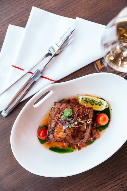 Poitrine de poulet juteuse au four et peau croustillante à la tomate et au citron servie avec du vin blanc.