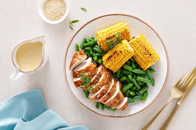 Poitrine de poulet rôtie avec des épis de maïs aux haricots verts et de la sauce pour le déjeuner