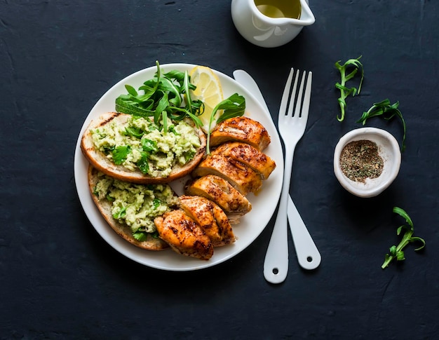 Poitrine de poulet rôtie et toast à l'avocat déjeuner sain sur fond sombre vue de dessus