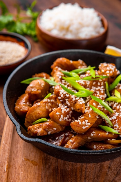 Poitrine de poulet teriyaki dans une poêle avec des graines de sésame close-up, cuisine asiatique traditionnelle