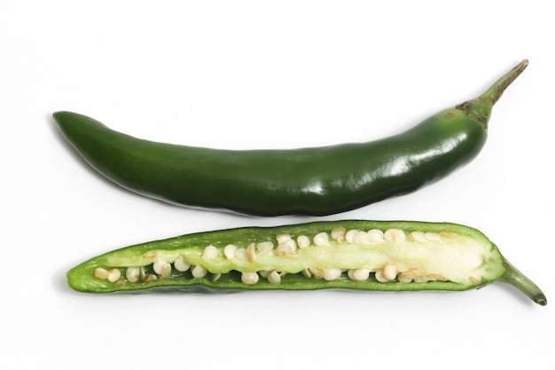 Photo poivre au piment vert chaud à moitié tranché isolé sur le chemin de coupe de fond blanc