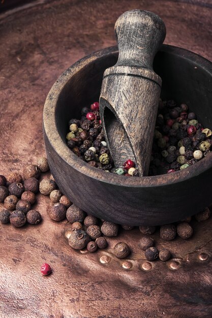 Poivre dans un mortier en bois avec une cuillère