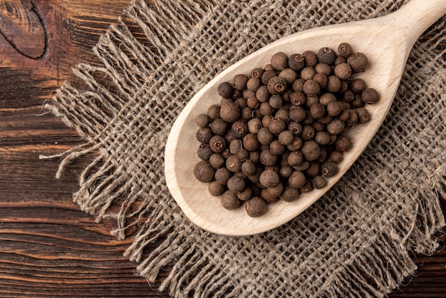 Poivre noir sur une cuillère en bois