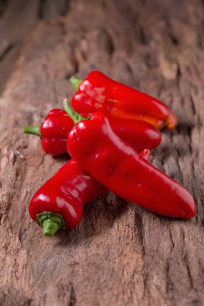 Poivre rouge sur fond noir en bois. Piments rouges chauds.