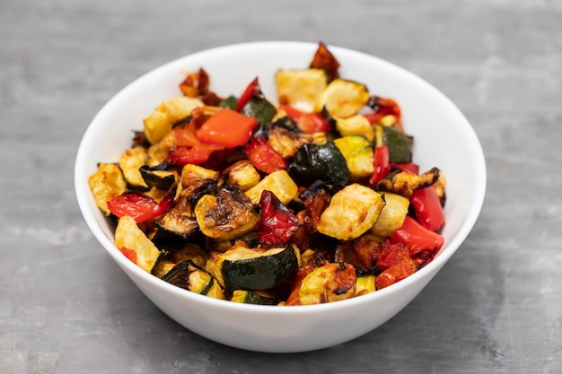 Poivre et tomate de courgette grillés dans la petite cuvette blanche