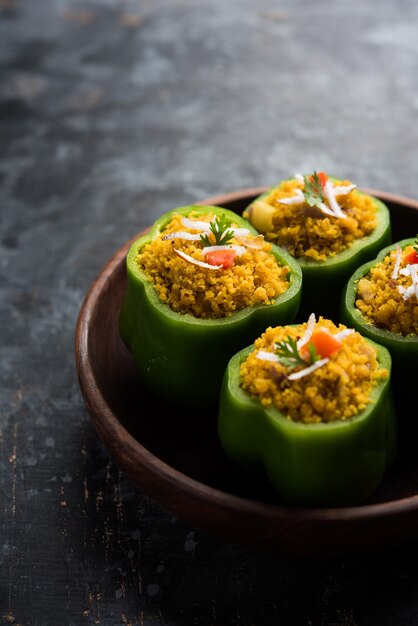 Le poivron farci ou bharwa shimla mirchi est une recette populaire de plat principal indien. Servi dans une assiette sur fond de mauvaise humeur. Mise au point sélective