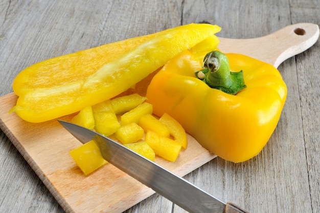 Poivron frais jaune tranché sur une surface en bois