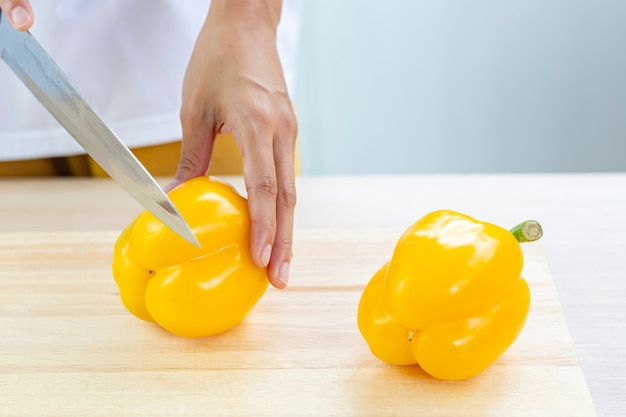 Poivron ou poivron doux et tranches sur une planche à découper en bois