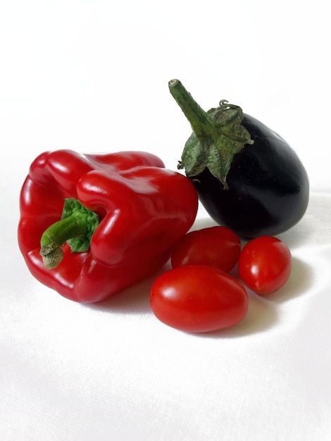 poivron rouge, aubergine et tomates cerises sur fond blanc