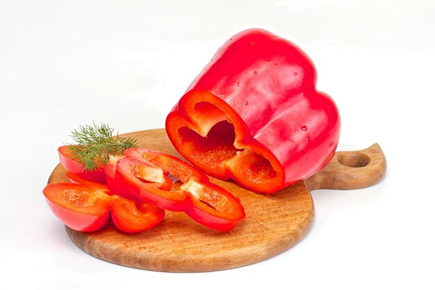 Poivron rouge vif à l'aneth sur le bureau en bois isolé sur blanc