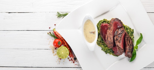 Photo poivron steak de veau aux épinards sur un fond en bois vue de dessus espace de copie