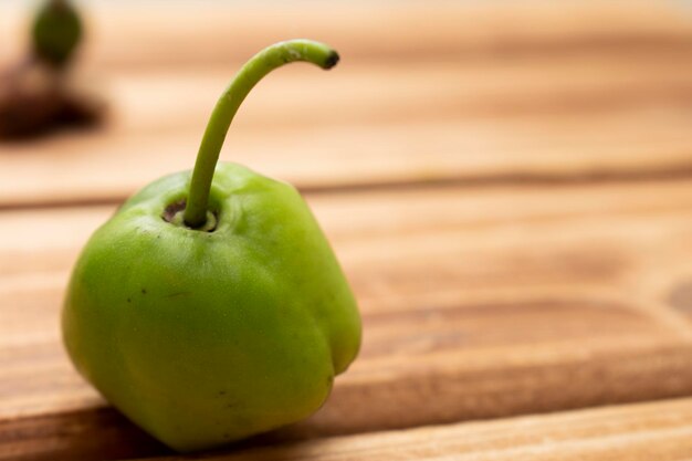 Un poivron vert sur une table en bois