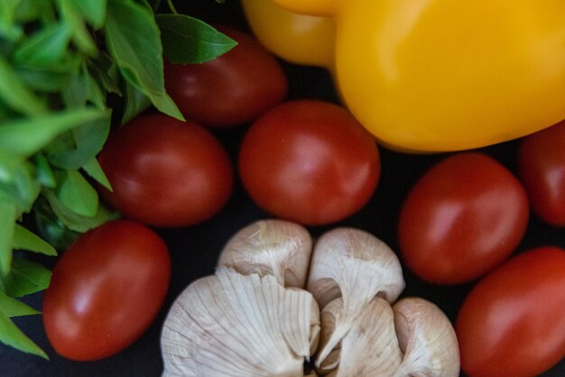 Des poivrons d'ail de basilic et des tomates cerises sur la table Des poivrots d'aillicots de Basilic et de tomates cherries sur la table