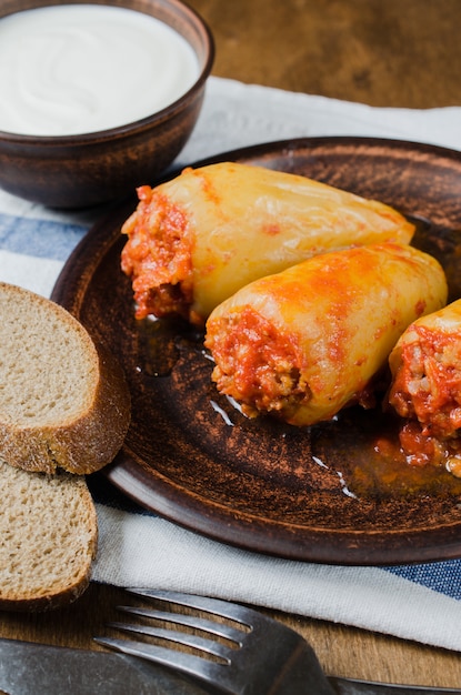 Poivrons farcis au riz et ragoût de viande hachée aux tomates, pain de seigle. Nourriture rustique.