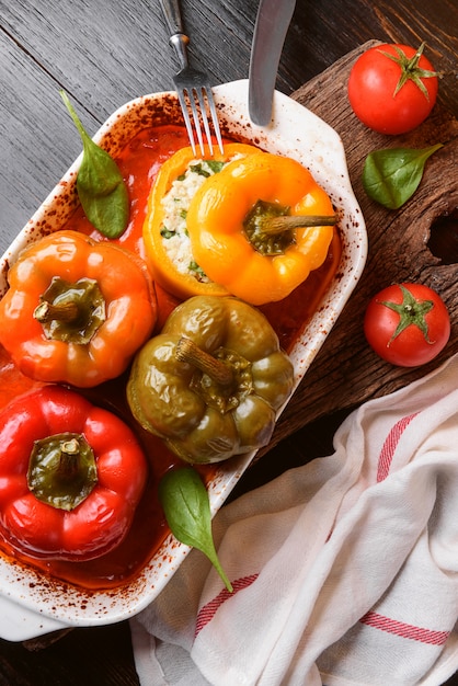 Poivrons farcis maison. avec une garniture de basilic, d'épinards, de fromage et d'épices. avec sauce de tomates fraîches faites maison. fait dans un style rustique.